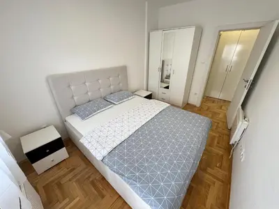 a bedroom with a large bed and a mirror at Apartment 4th. Floor in Banja Luka