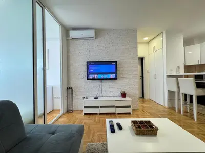 a living room with a couch and a tv on a brick wall at Apartment 4th. Floor in Banja Luka
