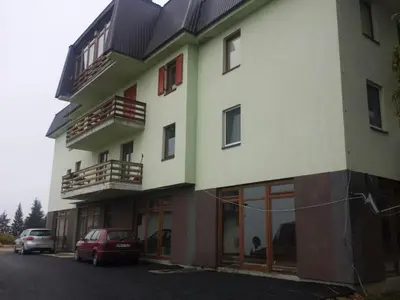 a building with cars parked in front of it at 4 Seasons Vlašić Lux Apartments in Vlasic