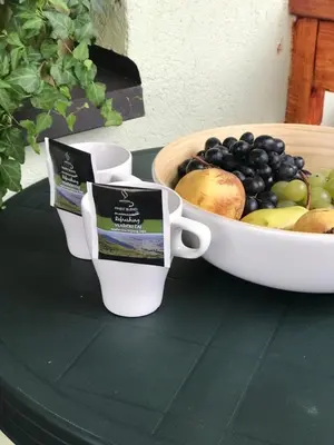 a bowl of fruit and two cups on a table at 4 Seasons Vlašić Lux Apartments in Vlasic
