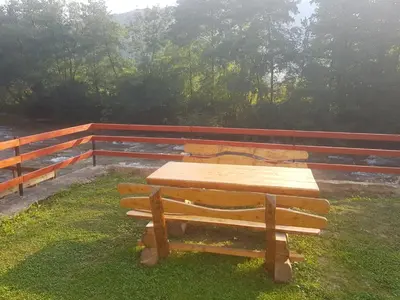a wooden table and bench next to a fence at Vinac guest house in Jajce