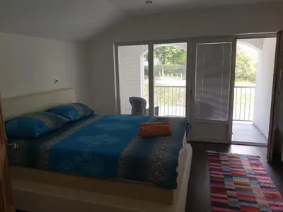 a bedroom with a bed with blue sheets and a balcony at Vinac guest house in Jajce