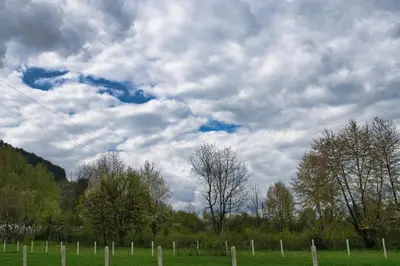 a kite flying in a cloudy sky over a field at Pyramid Energy House in Visoko