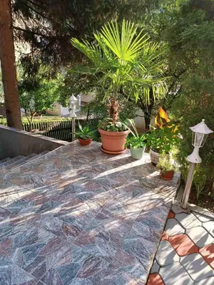 a patio with plants and potted plants on it at Obiteljski Apartman Borovi in Visoko