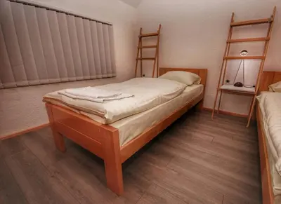 a small bedroom with a bed and two shelves at Apartmani 077 in Drvar