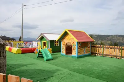a playground with several playhouses and a slide at Eko-FIS Vlašić in Vlasic