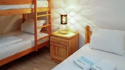 a bedroom with two bunk beds and a lamp on a night stand at Eko-FIS Vlašić in Vlasic