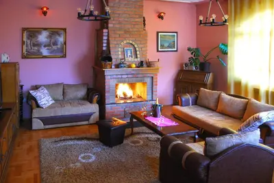 a living room with a couch and a fireplace at Villa Katarina with pool in Banja Luka