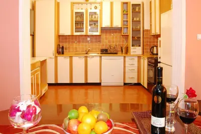 a kitchen with a table with a bowl of fruit and a bottle of wine at Villa Katarina with pool in Banja Luka