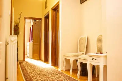 a hallway with two white chairs and a table at Villa Katarina with pool in Banja Luka