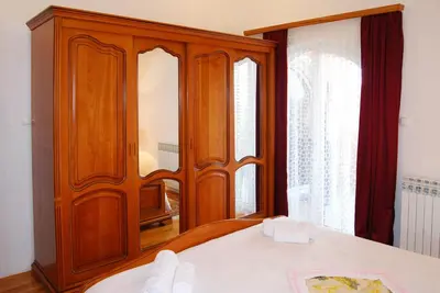 a bedroom with a wooden cabinet with a mirror at Villa Katarina with pool in Banja Luka