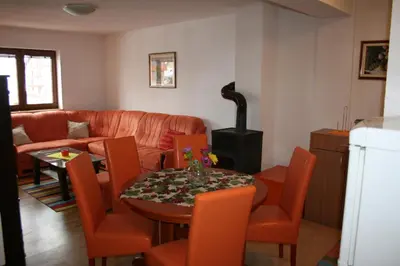 a living room with a couch and a table and chairs at Apartman Kupres Holiday in Kupres
