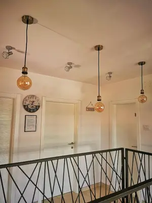 a staircase with lights and a clock on the wall at Apartman Ananas Banja Luka centar bolnica besplatan parking in Banja Luka