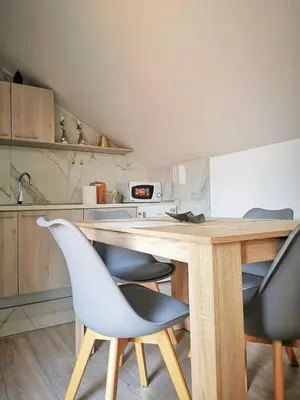 a kitchen with a wooden table and two chairs at Apartman Ananas Banja Luka centar bolnica besplatan parking in Banja Luka