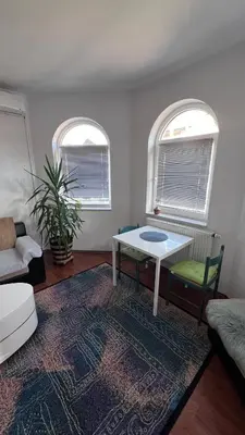 a living room with a table and two windows at Fortuna in Banja Luka