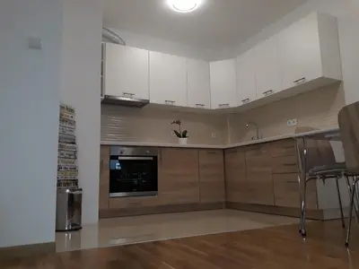a kitchen with white cabinets and a counter top at Apartman Lukana in Banja Luka