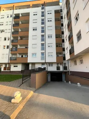 a parking lot in front of a large apartment building at Apartman Lukana in Banja Luka