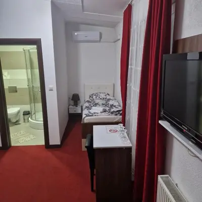 a small room with a bed and a television at Motel Dreams in Novi Travnik
