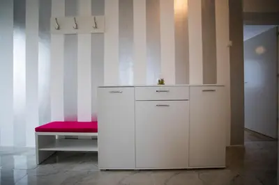 a room with a bench and a white cabinet at Guest house PiN in Laktaši