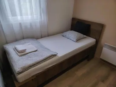 a small bed in a small room with a window at Guest house PiN in Laktaši