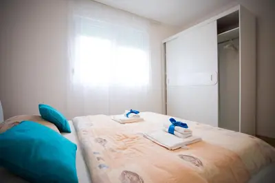 a bedroom with a bed with towels and a window at Guest house PiN in Laktaši