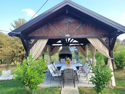 a wooden pavilion with a table and chairs at Guest house PiN in Laktaši