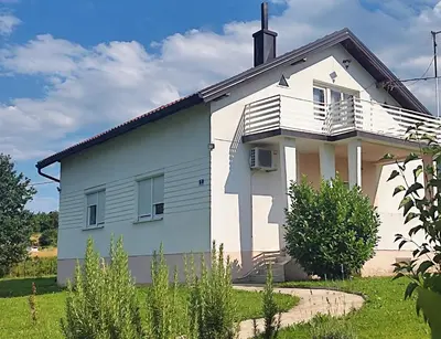 a white house with a balcony on top of it at Guest house PiN in Laktaši
