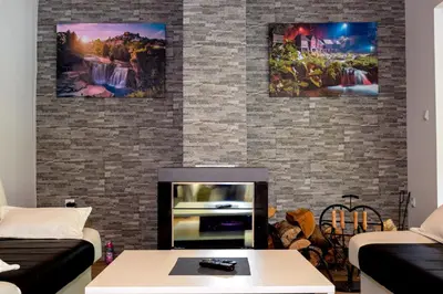 a living room with two couches and a fireplace at Forest Dream Lake House in Jajce