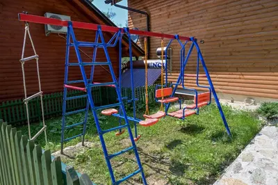 a playground with a blue and red swing at Forest Dream Lake House in Jajce