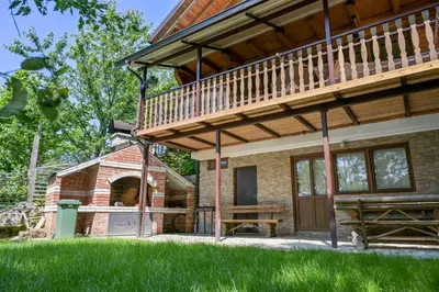 a large house with a deck and a barn at Forest Dream Lake House in Jajce