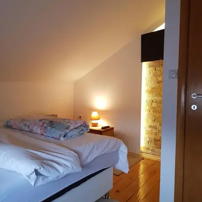 a bedroom with a bed and a lamp on a table at Vila Breza in Laktaši