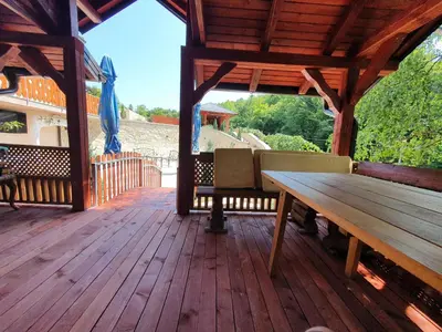 a wooden porch with a wooden bench on a wooden deck at Vila Breza in Laktaši
