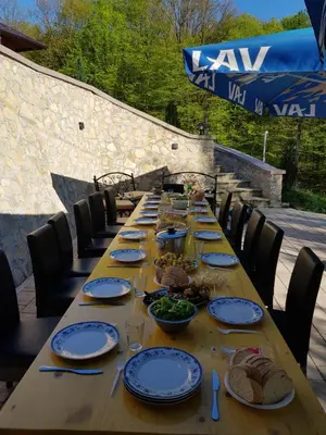 a long wooden table with plates of food on it at Vila Breza in Laktaši