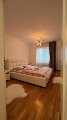 a bedroom with a large bed and a window at apartman nejra in Tuzla