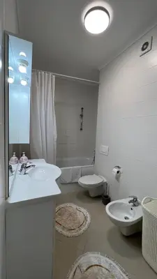 a white bathroom with two sinks and a toilet at apartman nejra in Tuzla
