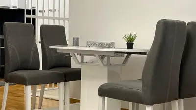 a dining room table with two chairs and a white table at apartman nejra in Tuzla
