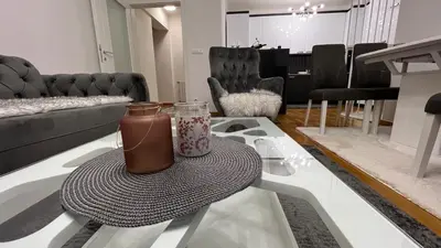 a living room with a table with a vase on it at apartman nejra in Tuzla