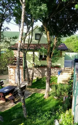 a house with a picnic table in the yard at Green House Izvor Vrilo in Tomislavgrad