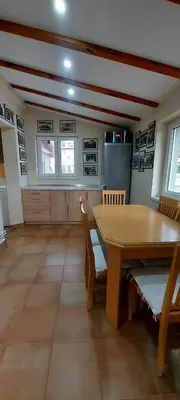 a dining room with a wooden table and chairs at Green House Izvor Vrilo in Tomislavgrad