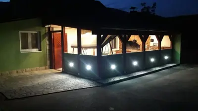 a house with lights on the side of it at night at Green House Izvor Vrilo in Tomislavgrad