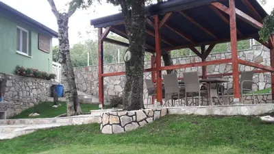 a pavilion with chairs and a table in a yard at Green House Izvor Vrilo in Tomislavgrad
