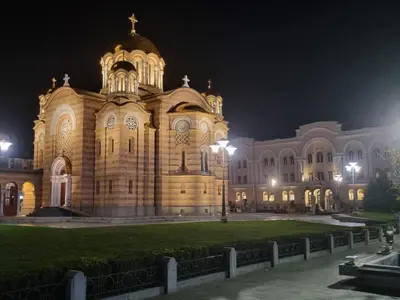 a large building at night with a green lawn in front at Park apartment in Banja Luka