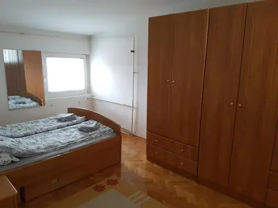a bedroom with a bed and a dresser and a window at Park apartment in Banja Luka