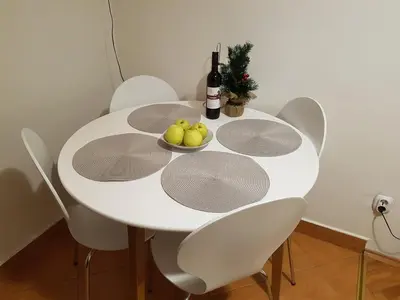 a white table with white chairs and a bowl of fruit at Park apartment in Banja Luka