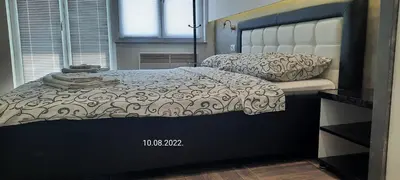 a bedroom with a bed with a black and white comforter at De Lux Apartment Maki in Banja Luka