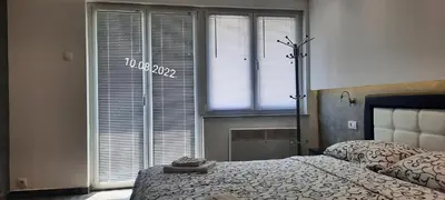 a bedroom with a bed and a large window at De Lux Apartment Maki in Banja Luka