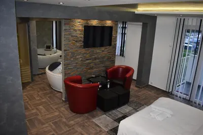 a hotel room with a bed and a tv on a brick wall at De Lux Apartment Maki in Banja Luka