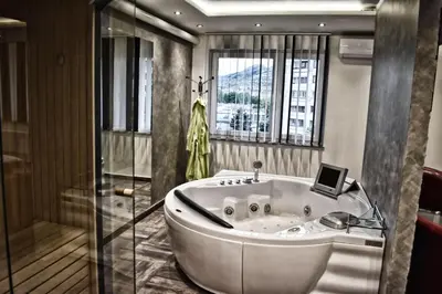 a bath tub in a bathroom with a window at De Lux Apartment Maki in Banja Luka