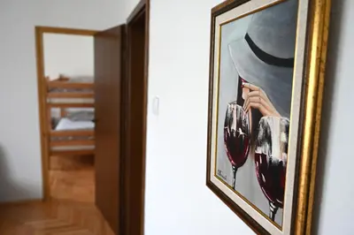 a framed picture of a woman in a hat and a bedroom at Apartman Felix in Laktaši