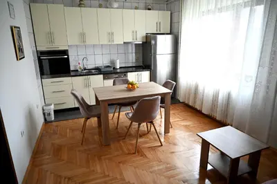 a kitchen with a table and chairs in a room at Apartman Felix in Laktaši